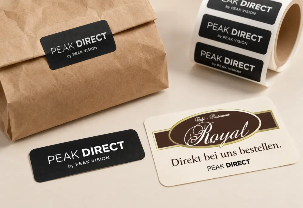 Designkonzept: PEAK-DIRECT-Sticker auf einer Papiertüte und Sticker mit Restaurantlogo