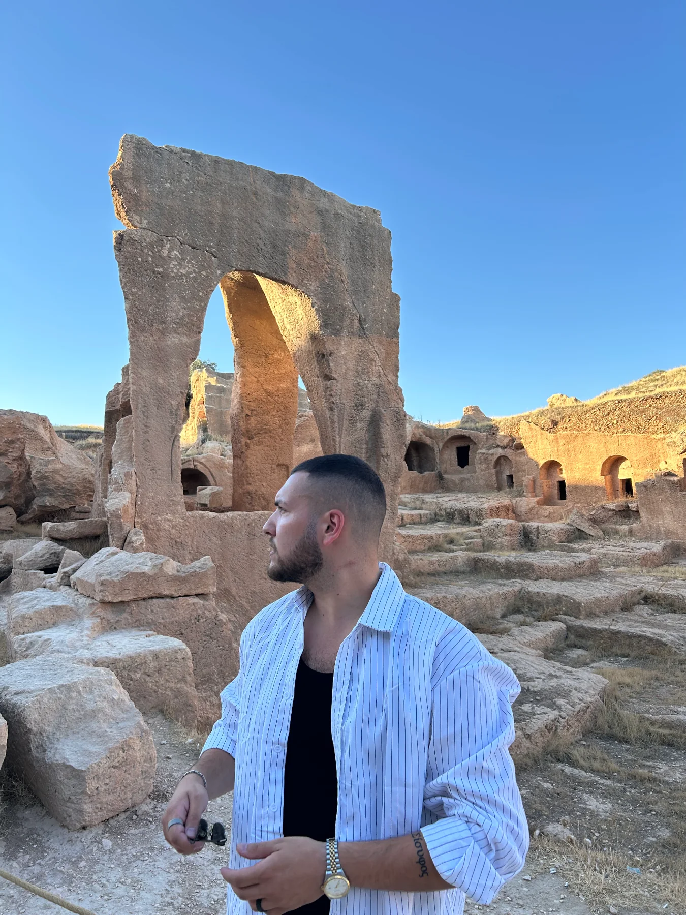 Koray Sahin auf einer Reise vor historischen Steinbauten
