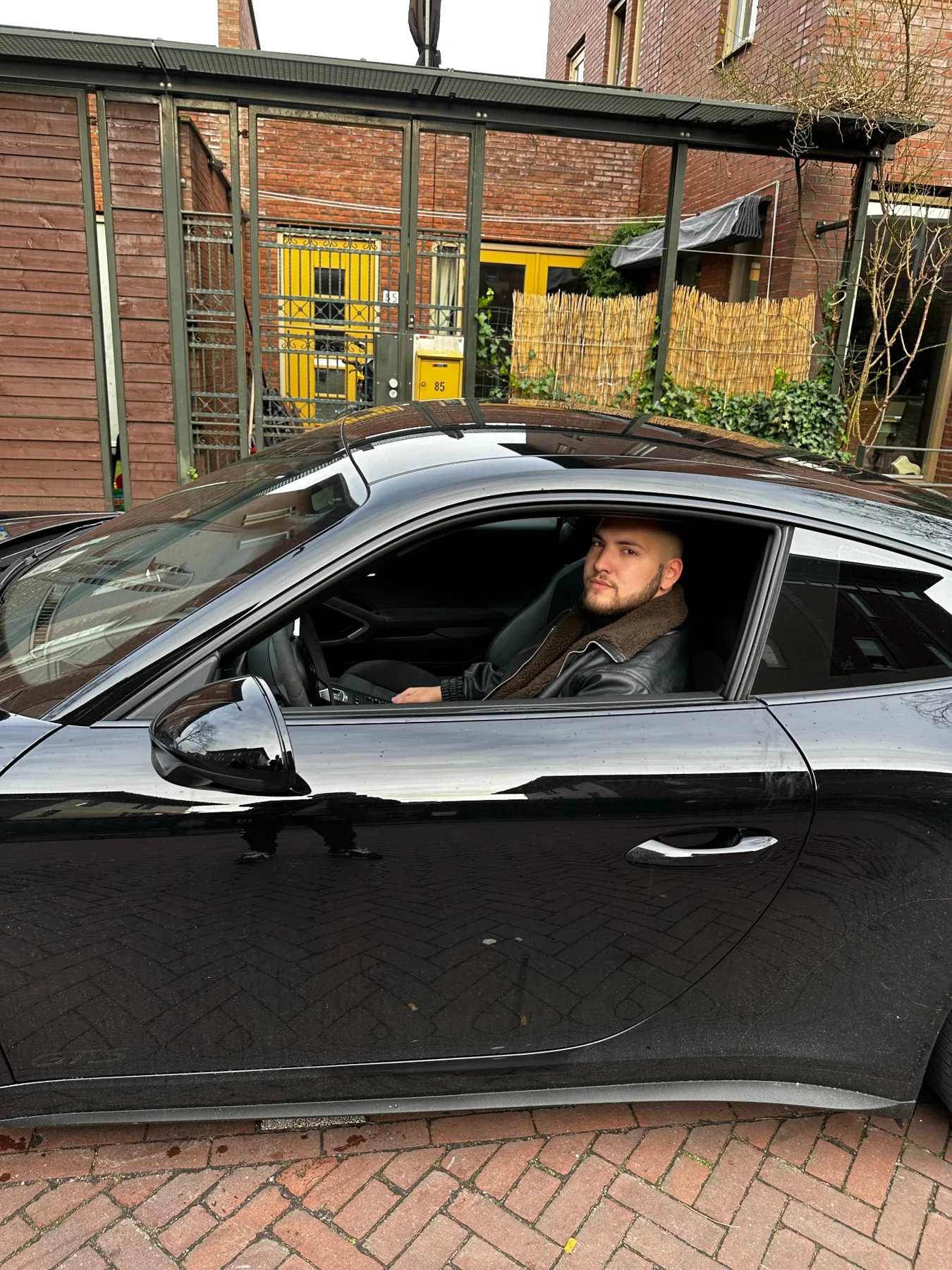 Koray am Steuer eines geparkten Autos